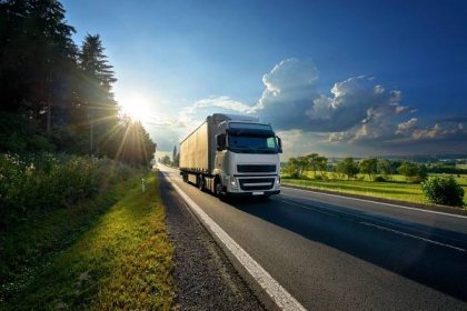 bílý kamion přijíždějící na asfaltovou silnici ve venkovské krajině v paprscích západu slunce - semi truck on road - stock snímky, obrázky a fotky