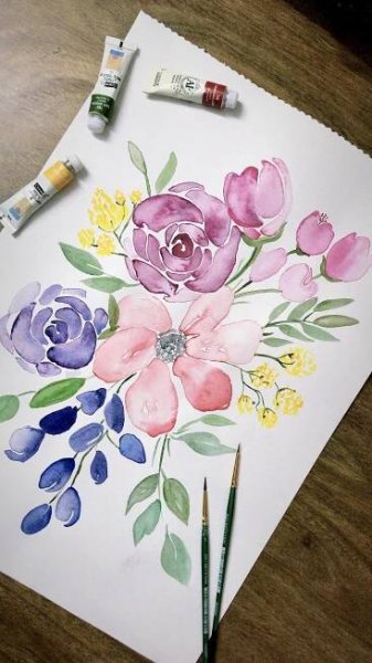 watercolor flowers are being painted on paper with paintbrushes next to the painting