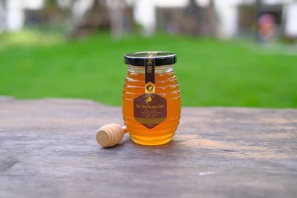 honey jar with label on wooden surface