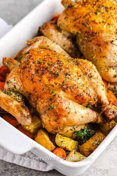 Cornish Hen se otře o bylinky a koření, poté se pečou do měkka a křupava. Pečené s bramborami, mrkví a cibulí, toto jídlo je kompletní a plné jídlo! #spendwithpennies #cornishhen #recept #maindish #ovenroasted #coced 