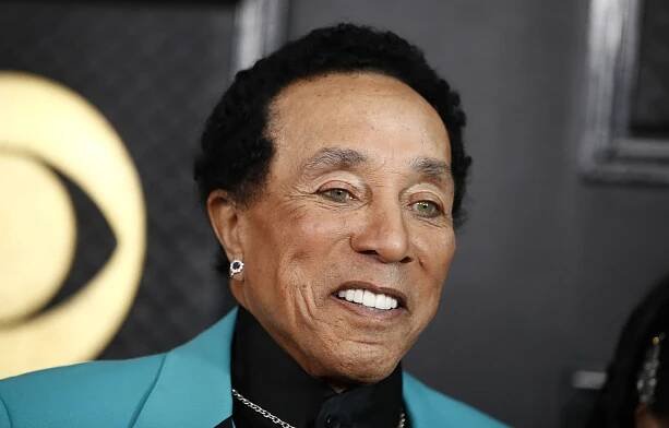 Smokey Robinson wearing a black shirt, a necklace and an earring.