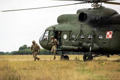 Army Pvt. Michael Alvarez and Army Spc. Wyatt McLean, both with 1st Battalion, 9th Cavalry Regiment, 1st Cavalry Division, exit a helicopter during joint operation Lancer Lift in Pisz, Poland, July 19, 2023. Operation Lancer Lift is a British-led exercise designed to enhance the interoperability between multinational forces during an aerial insertion operation.
