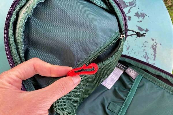 hand holds key clip from pocket of Osprey Daylite Sling Backpack