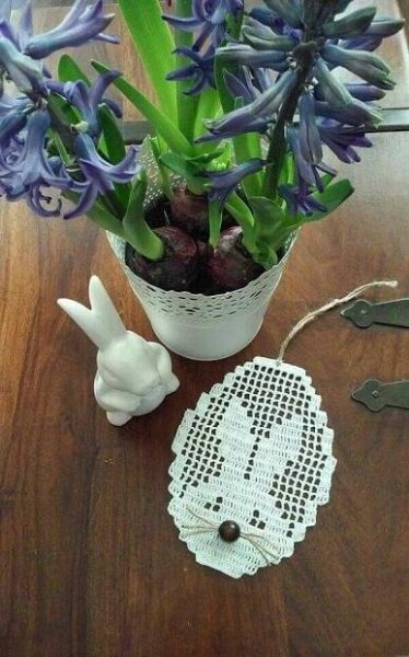 a potted plant sitting on top of a wooden table next to a doily