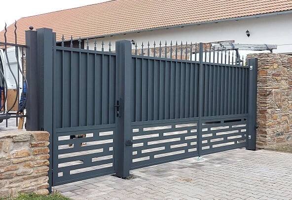 Sestava dvoukřídlé vjezdové kovové brány a branky atypického designu kombinovaného z kovářských neprůhledných výplní a designovým plechem. Barva antracit. Výroba brány s brankou na míru v obci Benešov.