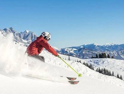 Skifahrer flitzt die Piste hinab in der SkiWelt Wilder Kaiser-Brixental.