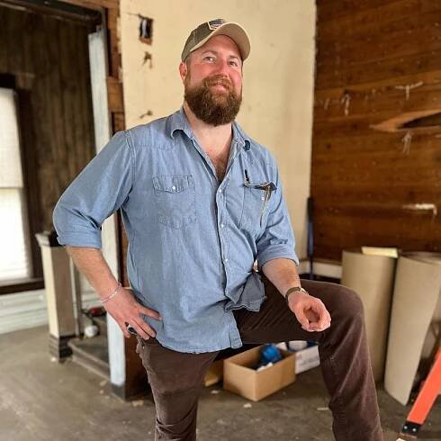 Ben Napier wears blue button down shirt and brown pants