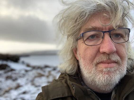 Bill Thompson - White man with blue glasses and long, shaggy white hair with short white beard.