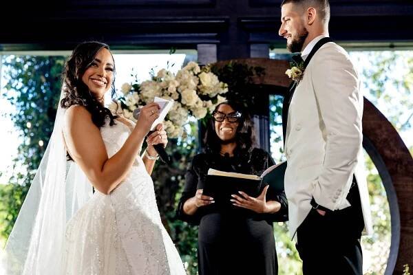 A funny bride sharing her vows and looking at her friends and family during the ceremony at a The Vale Wedding in Conroe, Texas