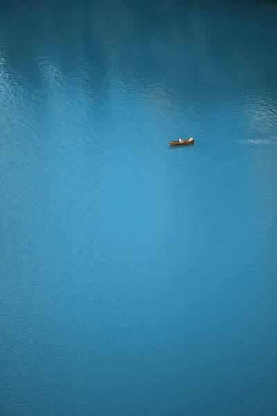 a small boat floating on top of a large body of water