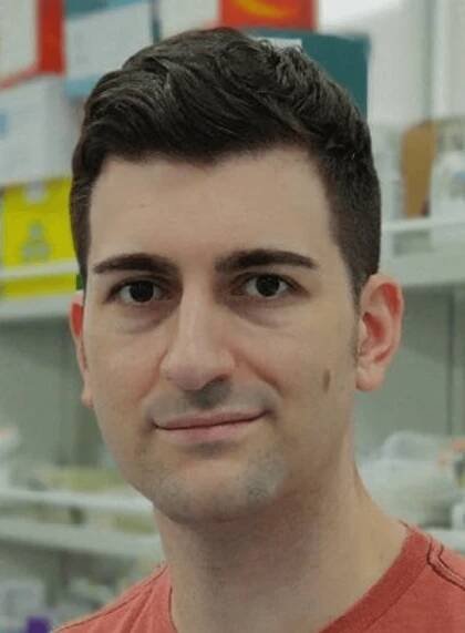 Alvaro Castells-Garcia, wearing a red shirt, poses in the laboratory.