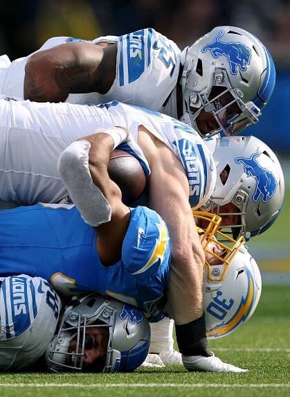 Los Angeles Chargers running back Austin Ekeler, second from bottom, is tackled by Detroit's Aidan Hutchinson and Derrick Barnes, top, during the Chargers' 41-38 loss to the Lions on November 12. Detroit linebacker Jack Campbell is on the bottom.