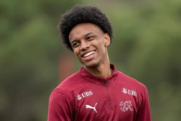 Alvyn Sanches, Schweiz Nationalspieler, lächelt bei einem Training im März 2025 mit einem dunkelroten Trikot.