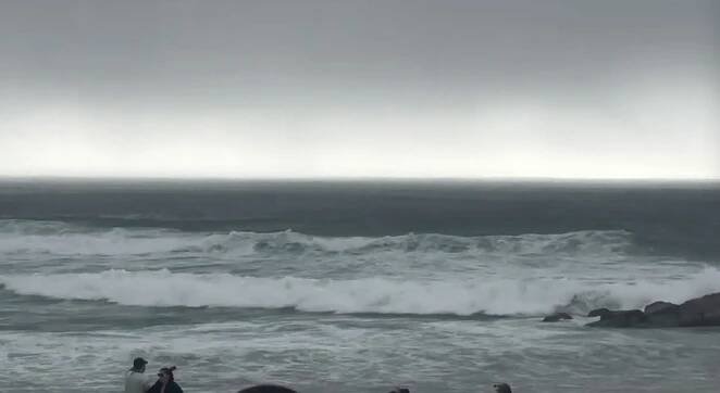 Beachgoers on a beach in Ovar, Portugal, as a storm approaches.