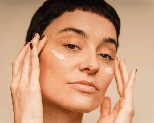 Close up of woman's face applying skincare