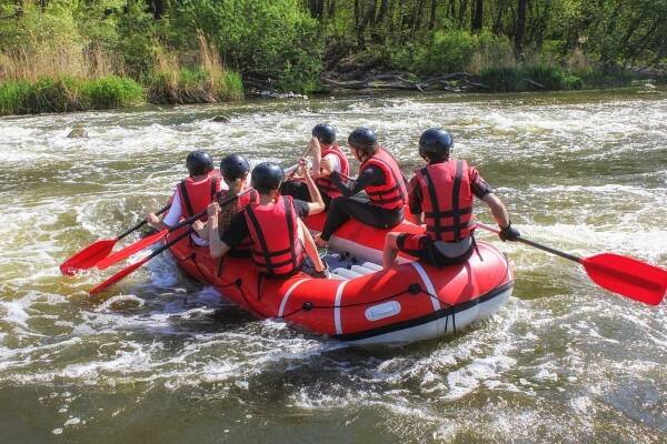 Group of people rafting through white waters.