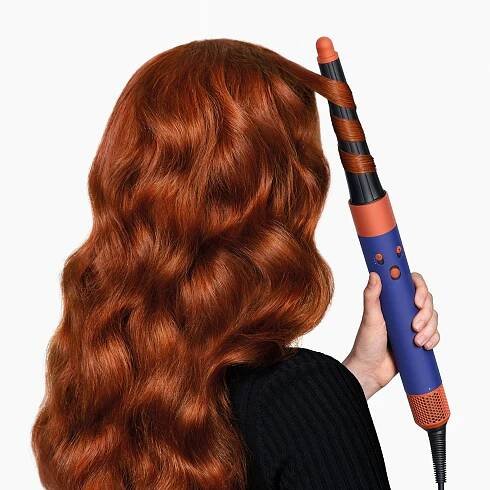 Modelka si natáčí vlasy pomocí multistyleru a vysoušeče vlasů Dyson Airwrap ID.