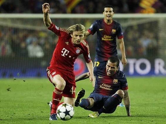 Daniel Alvés z Barcelony se snaží zastavit Tjimoščuka z Bayernu.