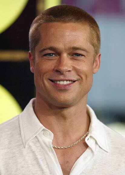 a man with a chain around his neck smiles for the camera