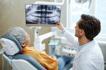 pohled zezadu na zubaře ukazujícího na rentgenový snímek zubu na obrazovce - dentist - stock snímky, obrázky a fotky