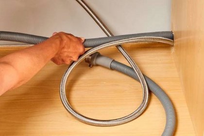 Dishwasher drain hose pulled under kitchen counter