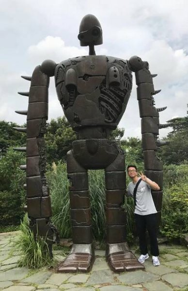 Alvin posing next to a Giant Robot statue