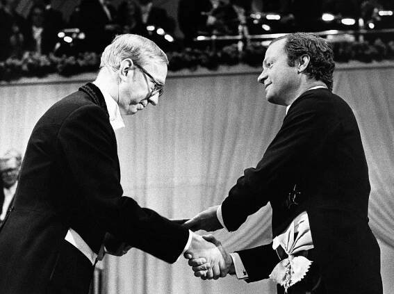 Bengt Samuelsson, a thin man with white hair and glasses, shakes hands with the king of Sweden. Both men are formally dressed and are seen in profile.