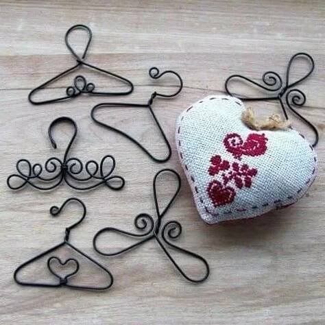 a heart shaped object sitting on top of a wooden table next to metal clothes pins