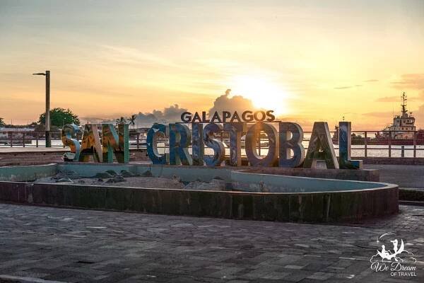 Sunset behind the "Welcome to San Cristobal Galapagos" sign on the main pier in Puerto Baquerizo Moreno