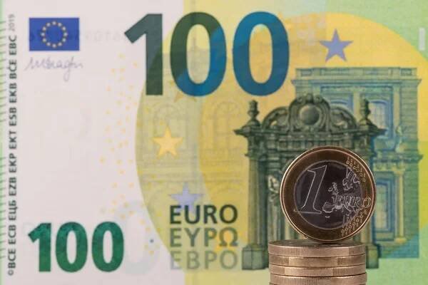Mince v hodnotě 1 euro na pozadí bankovky ve výši 100 eur — Stock obrázek