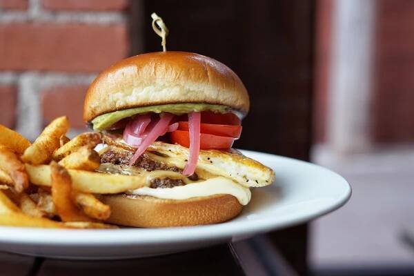 Menu Photography of  the Order's breakfast burger in a rooftop dining area. Photography by Amy Hess,