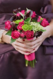 Nevěsta v tmavě fialových šatech s kyticí růží