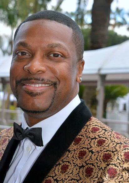 a man in a tuxedo smiles at the camera