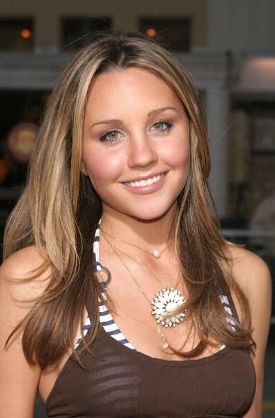 a beautiful young woman wearing a brown and white top