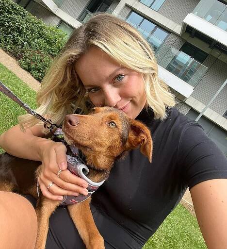 Woman hugging her brown puppy.