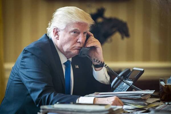 President Donald Trump on the phone in the Oval Office.