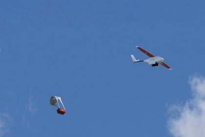 When the drone reaches its destination, its payload is released over a predetermined area and is parachuted down to the ground