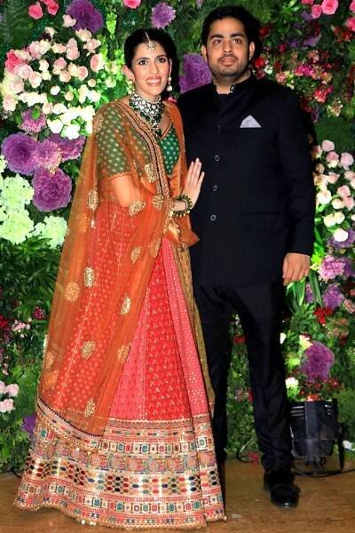Image may contain Akash Ambani Clothing Apparel Human Person Sari Silk Coat Dress Flower Plant Blossom and Suit