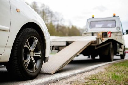 Loading broken car on a tow truck on a roadside Stock Photo by ©nejron 72049931