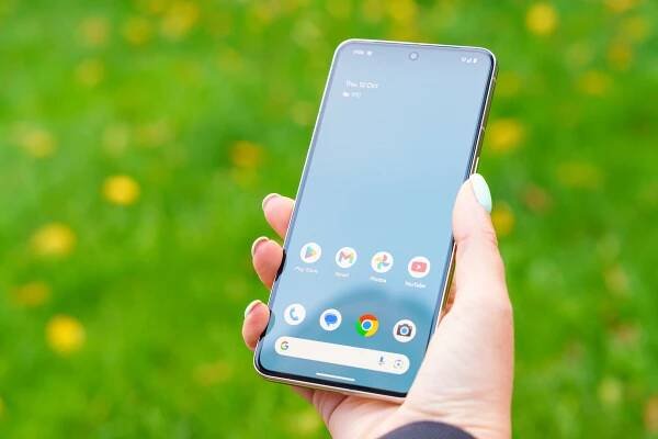 Close-up of a hand holding a Google Pixel 8 Pro showing the home screen.