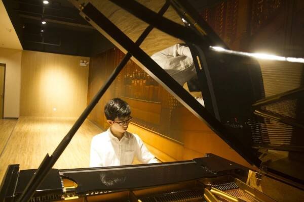 Kingsley playing the piano in China
