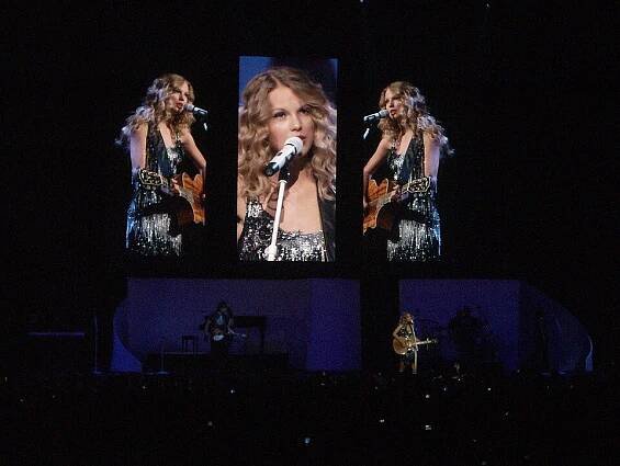 Taylor Swift donning a sparkling cocktail dress and playing a rhinestoned acoustic guitar