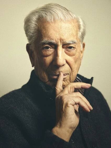 an old man is holding his finger to his chin and looking at the camera with a serious look on his face