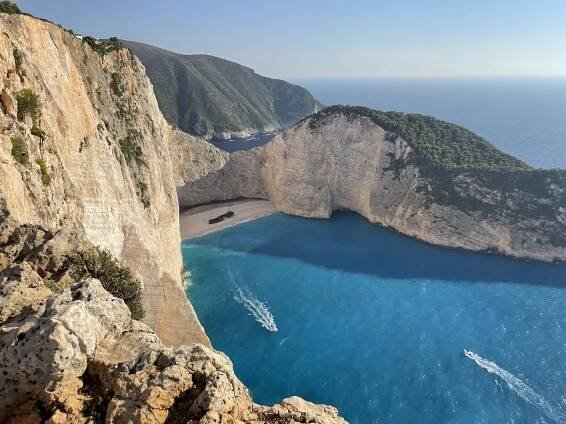 Úchvatný výhled na pláž Navagio, obklopenou tyčícími se útesy a slavným vrakem na bílém písčitém pobřeží.