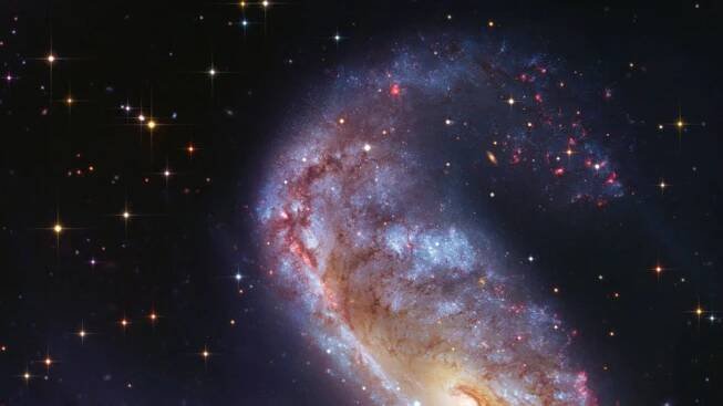 Hubbleův vesmírný dalekohled nasnímal unikátně tvarovanou galaxii. Vypadá jako hák na maso