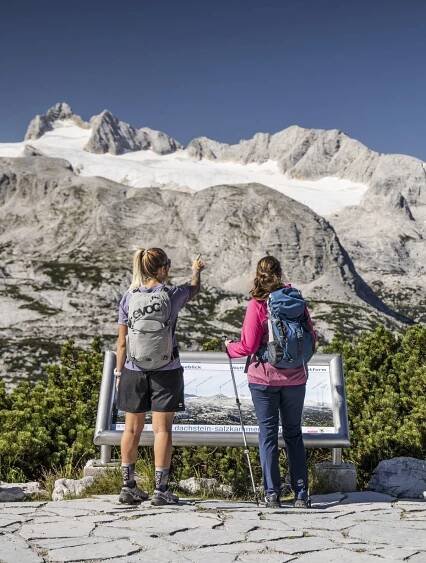 Zwei Frauen stehen beim Welterbeblick und betrachten den Dachstein Gletscher