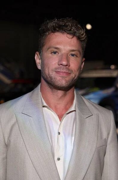 Ryan Phillippe wearing a stylish suit and shirt, smiling at an event