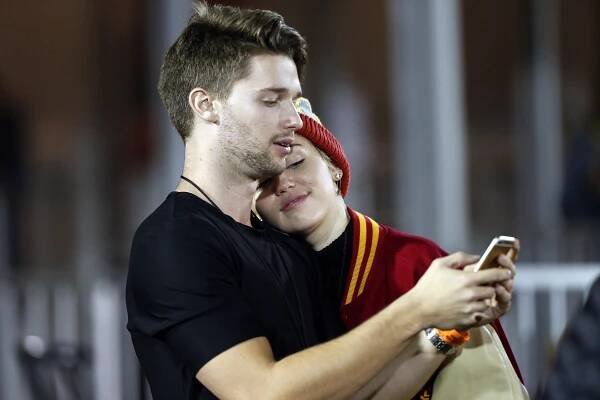 Patrick Schwarzenegger and Miley Cyrus at a football game in 2014