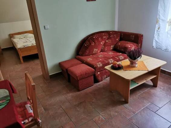 a living room with a red couch and a table at Penzion Mia in Dolní Moravice