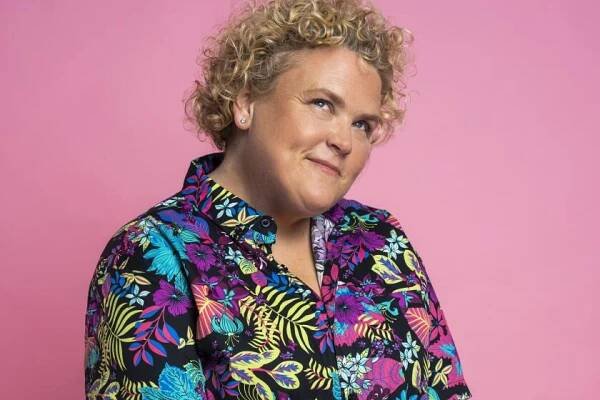 Woman with short blond hair and colorful colored shirt